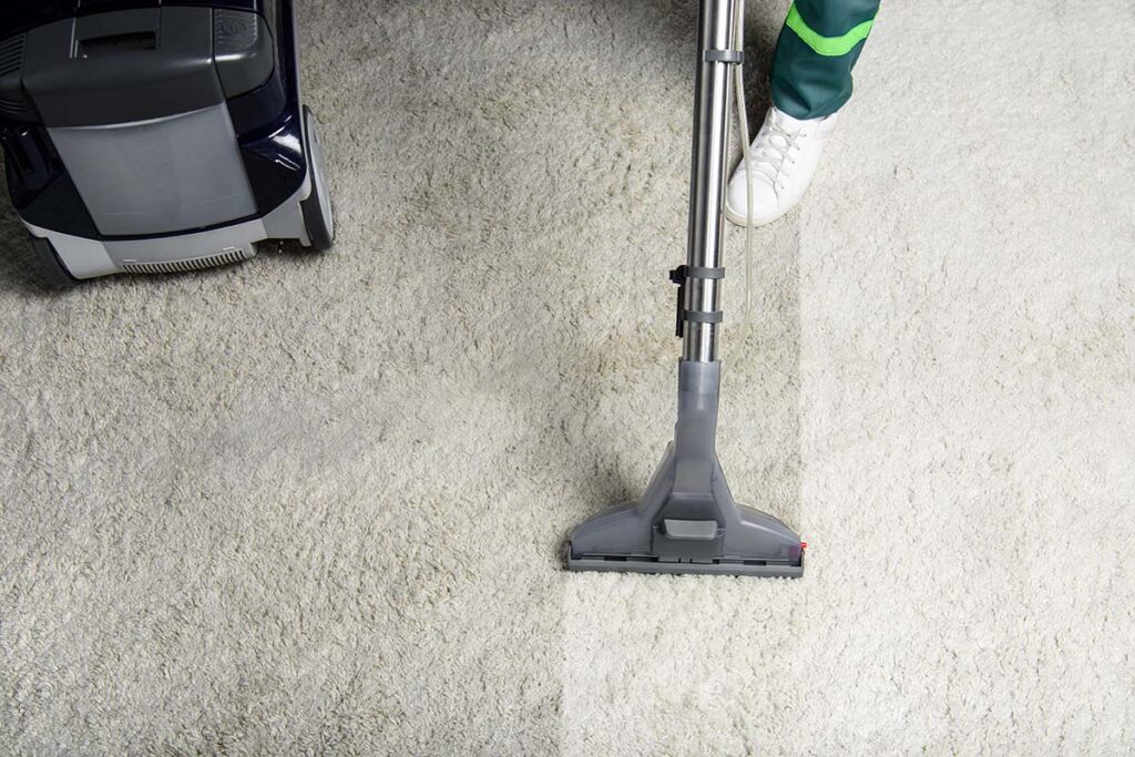 person cleaning white carpet with professional vacuum cleaner in London