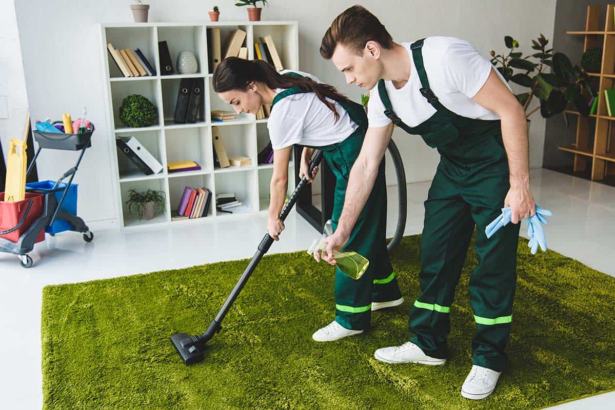 couple of professional cleaners vacuuming a carpet in Barking