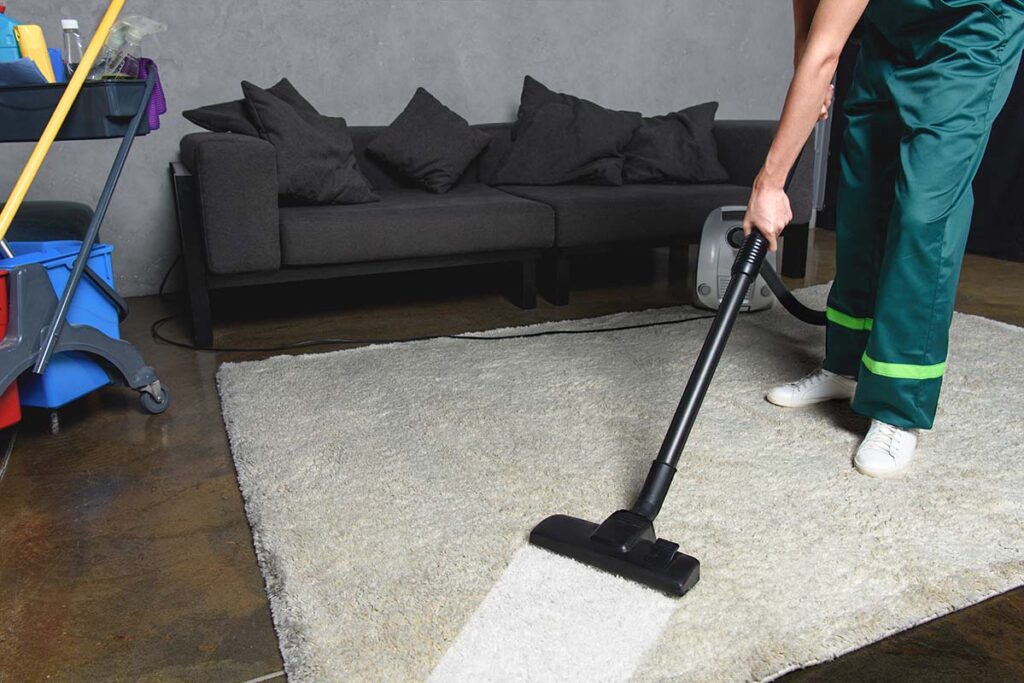 professional cleaner vacuuming a white carpet