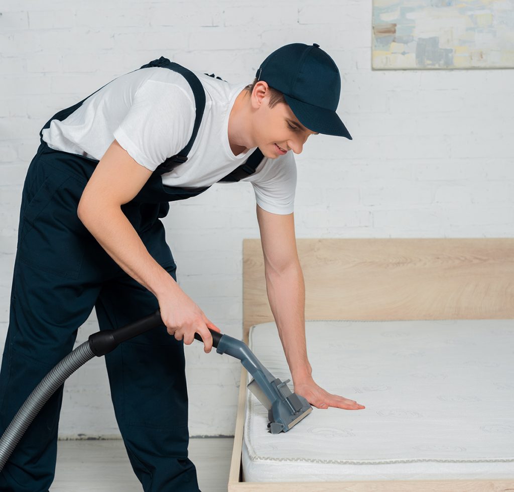 professional cleaner vacuuming a mattress