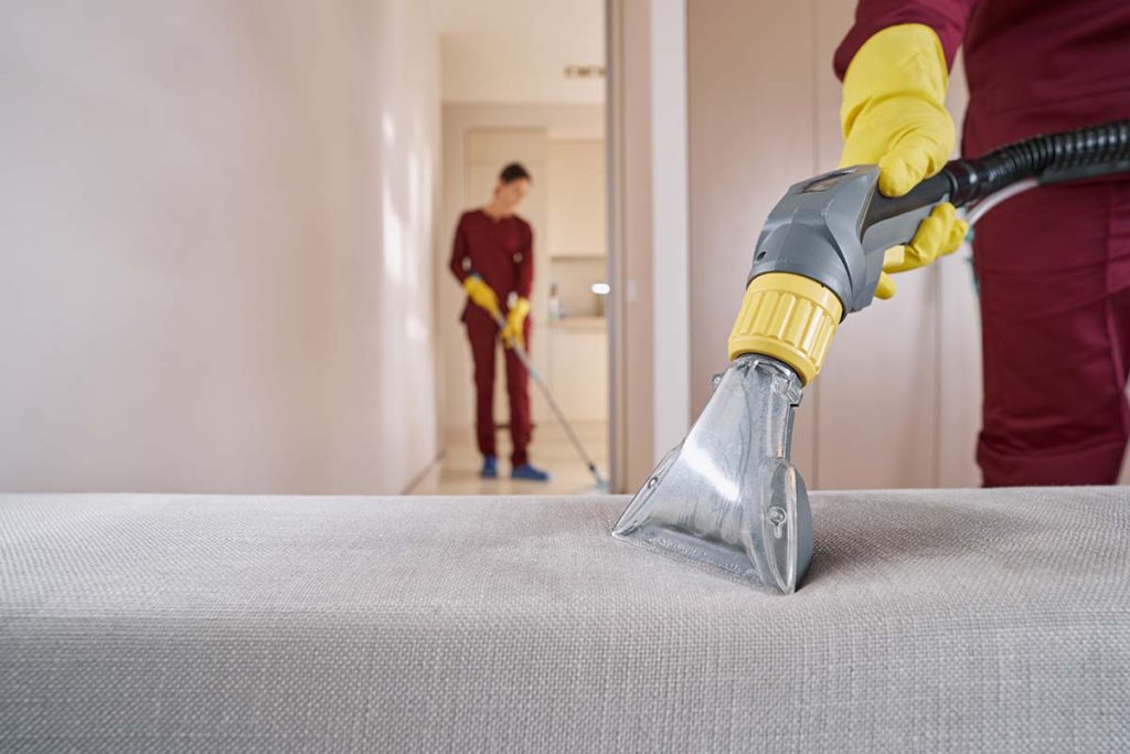 professional end of tenancy team cleaning a sofa in morden